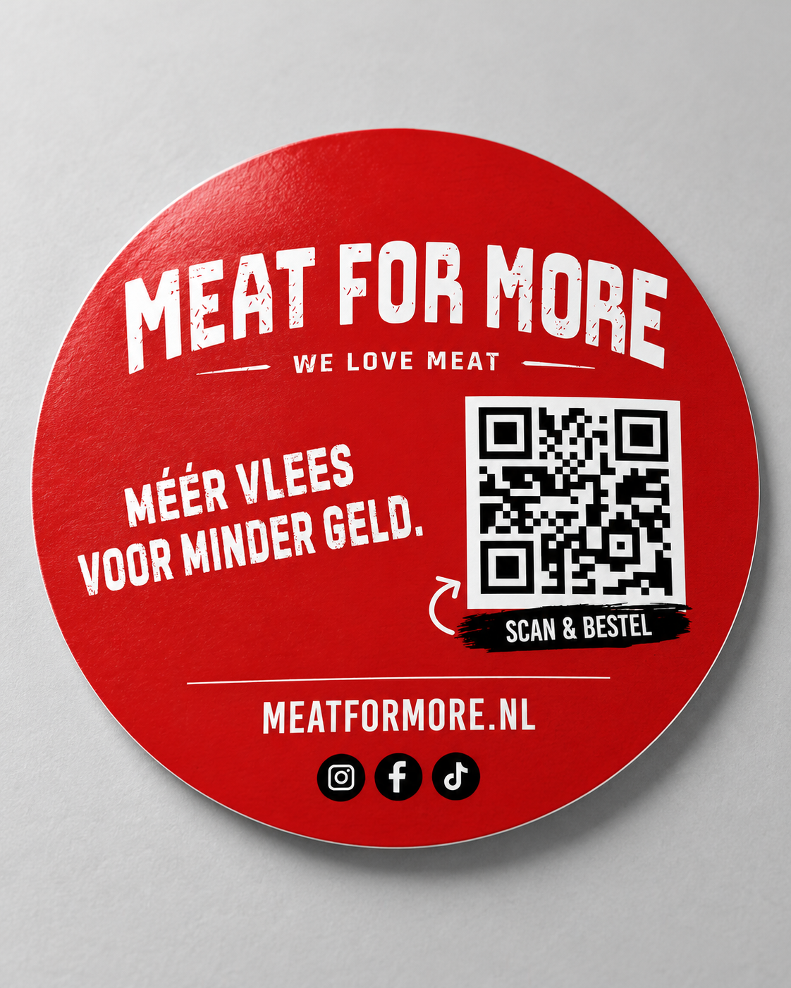 Rood rond stickerdesign voor Meat for More met wit logo, slogan en QR-code, ontworpen door Baas in Beeld.