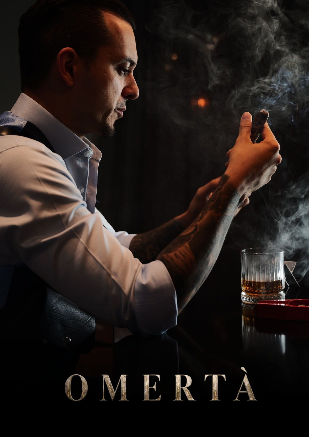 Donker portret van een man aan een tafel met glaswerk tijdens een cinematic fotoshoot